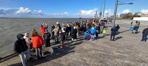 Menschen an der Pier winken dem Schiff