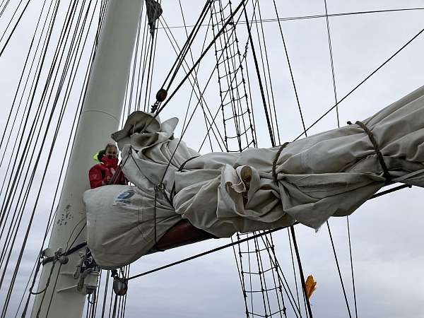 Bosun Hanni beim Reparieren des Großstagsegels 