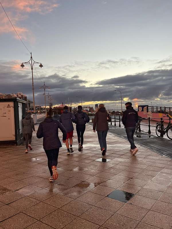 Die Laufgruppe ist an der Strandpromenande unterwegs