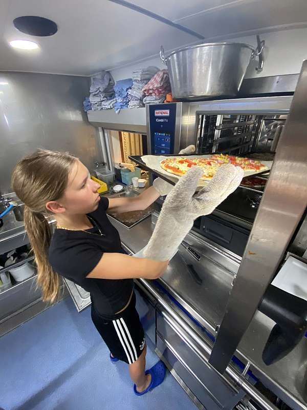 Maia ist die Pizza Managerin am Ofen